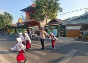 Polsek Rastim Bantu Seberangkan Anak Sekolah, Arus Lalu Lintas Tetap Lancar